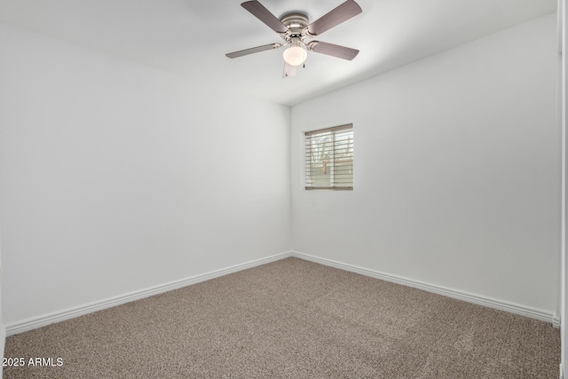 carpeted spare room with ceiling fan and baseboards