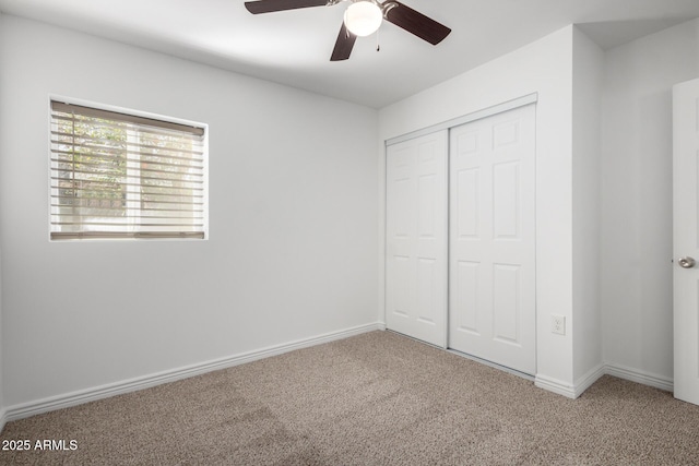 unfurnished bedroom featuring a closet, carpet flooring, ceiling fan, and baseboards