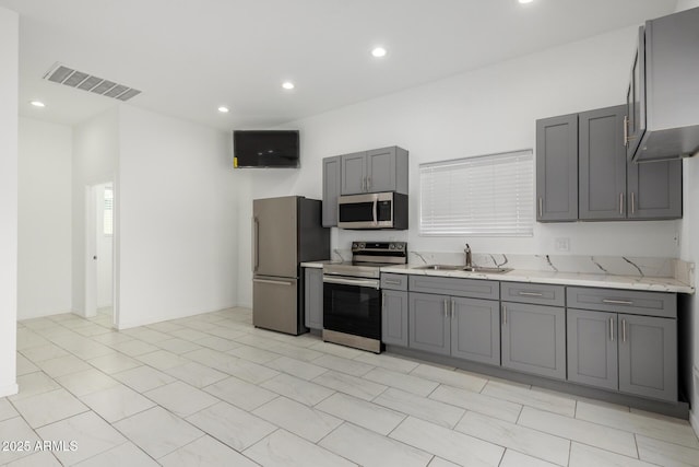 kitchen with visible vents, appliances with stainless steel finishes, gray cabinets, a sink, and recessed lighting