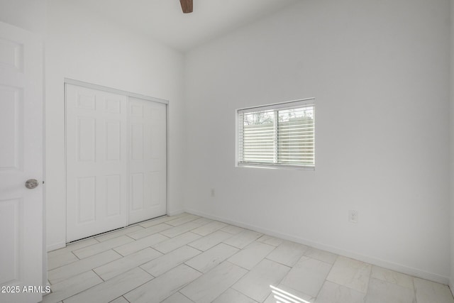 unfurnished bedroom featuring ceiling fan, baseboards, and a closet