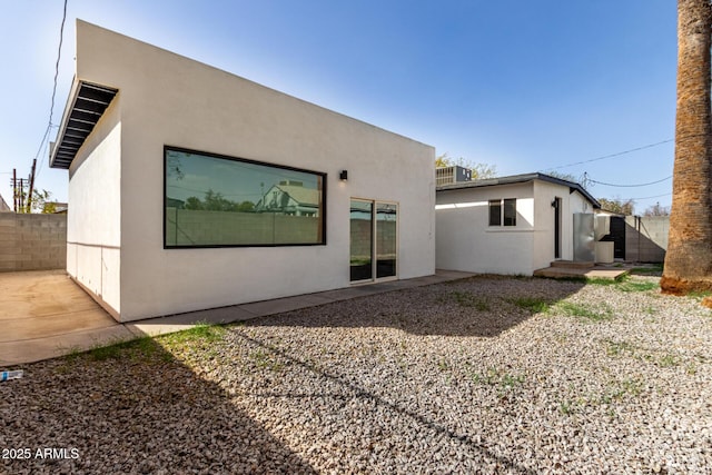 back of property featuring a patio area, fence, and stucco siding