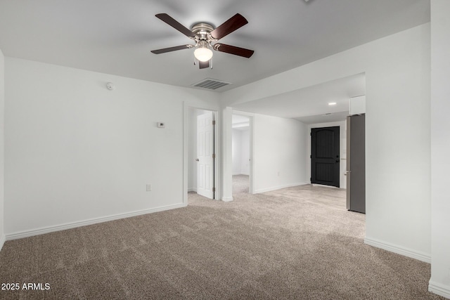 spare room with baseboards, a ceiling fan, visible vents, and light colored carpet