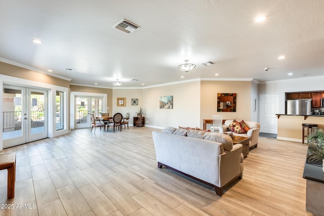 living room with light wood finished floors, french doors, visible vents, and recessed lighting