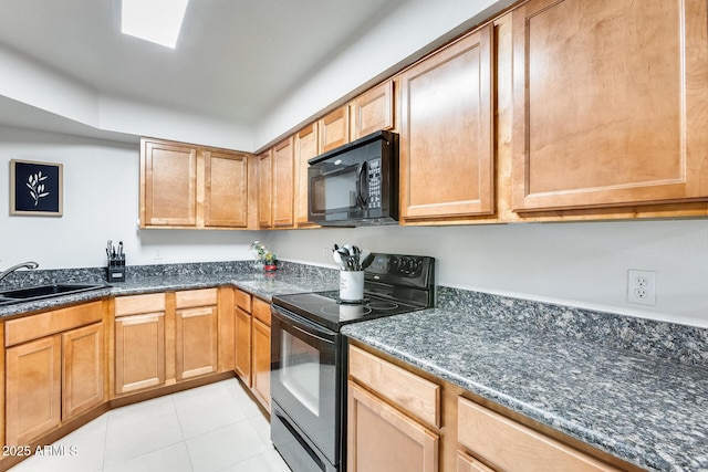 kitchen with light tile patterned floors, a sink, dark stone countertops, and black appliances