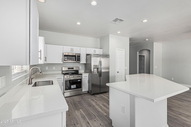9224 W Raymond St, Tolleson, AZ 85353 - kitchen featuring stainless steel appliances, arched walkways, recessed lighting, light wood-type flooring, and a kitchen island