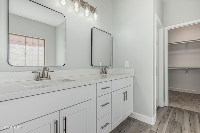 9224 W Raymond St, Tolleson, AZ 85353 - bathroom with double vanity, wood finished floors, and a walk in closet