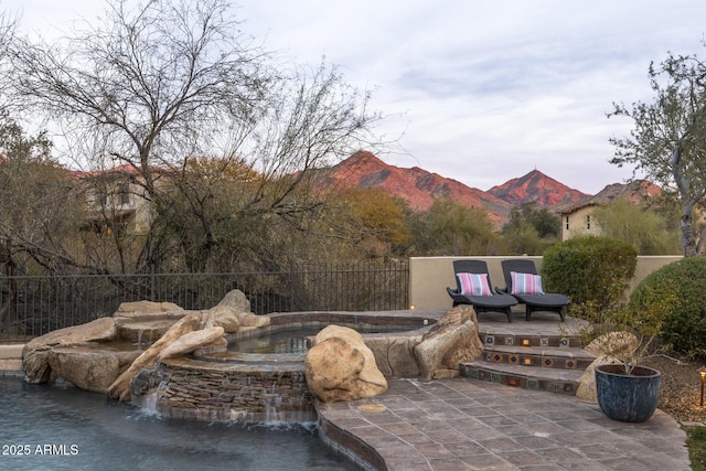 view of pool featuring a mountain view, a patio area, and pool water feature