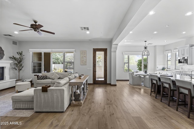 living room featuring ceiling fan and light wood-type flooring