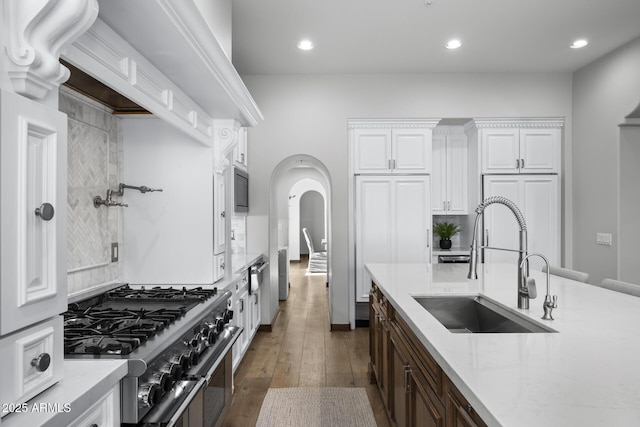 kitchen featuring white cabinetry, double oven range, sink, and built in microwave