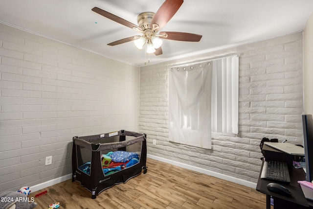 bedroom with brick wall, ceiling fan, ornamental molding, and light hardwood / wood-style floors