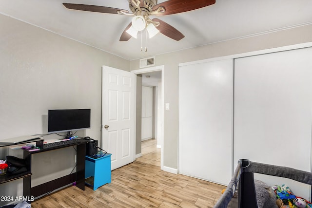 office with light wood-type flooring and ceiling fan