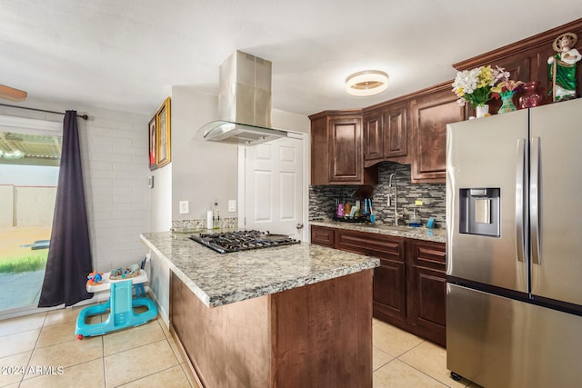 kitchen with backsplash, light stone countertops, stainless steel appliances, island exhaust hood, and light tile patterned flooring