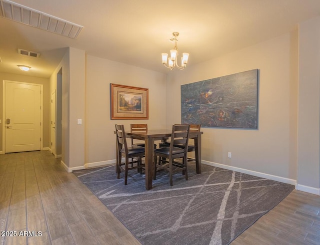 dining room featuring dark hardwood / wood-style flooring and an inviting chandelier