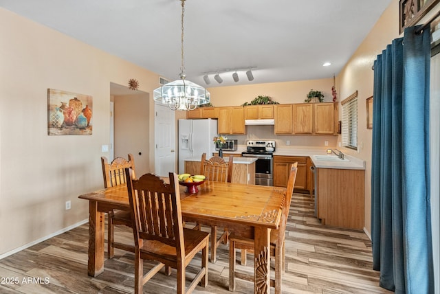 dining area featuring visible vents, baseboards, rail lighting, a notable chandelier, and light wood-type flooring