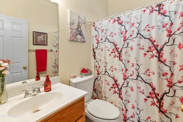 bathroom featuring vanity, a shower with shower curtain, and toilet