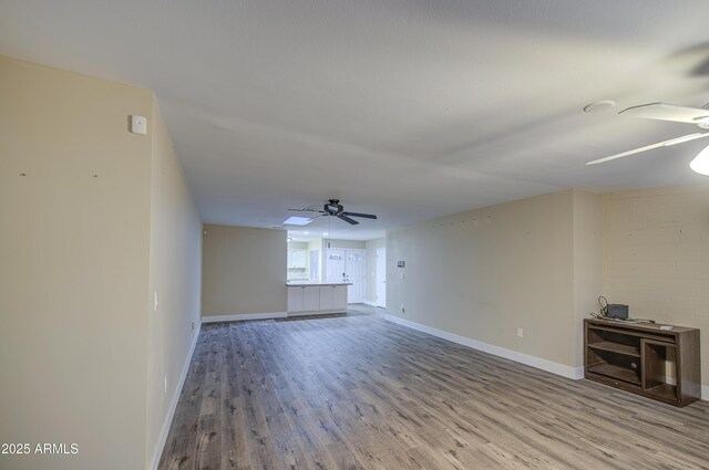 10620 W Clair Dr, Sun City, AZ 85351 - unfurnished living room featuring ceiling fan, wood finished floors, and baseboards