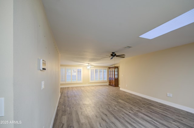 10620 W Clair Dr, Sun City, AZ 85351 - unfurnished living room featuring baseboards, wood finished floors, and a ceiling fan