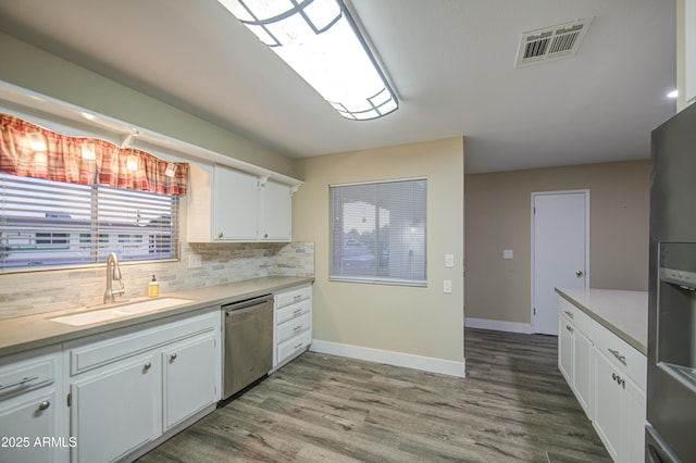10620 W Clair Dr, Sun City, AZ 85351 - kitchen with dishwasher, a sink, light countertops, and white cabinets