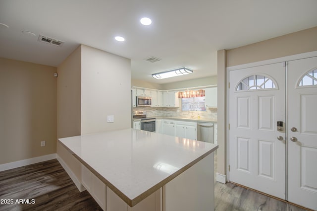 10620 W Clair Dr, Sun City, AZ 85351 - kitchen featuring stainless steel appliances, a peninsula, dark wood-style flooring, light countertops, and recessed lighting
