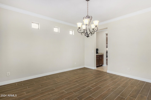 unfurnished room with dark hardwood / wood-style flooring, crown molding, and an inviting chandelier