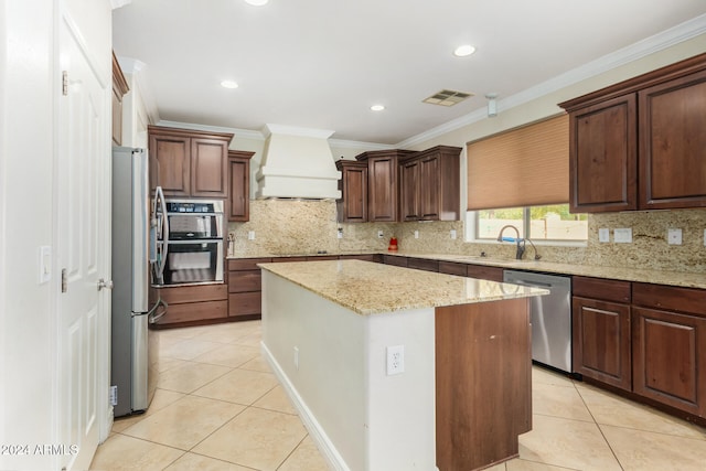 kitchen featuring custom exhaust hood, a kitchen island, light tile patterned floors, and stainless steel appliances