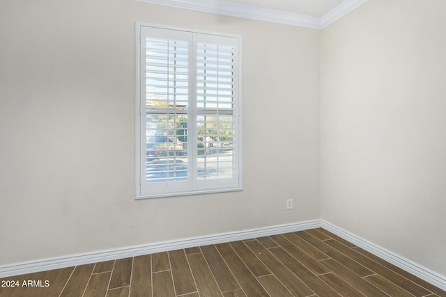 spare room featuring dark hardwood / wood-style flooring and crown molding