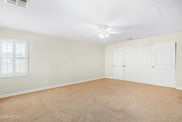 unfurnished bedroom featuring carpet flooring, ceiling fan, and a closet