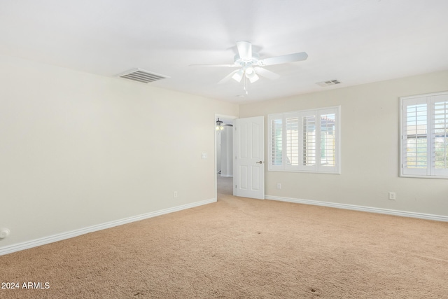 unfurnished room featuring light colored carpet and ceiling fan