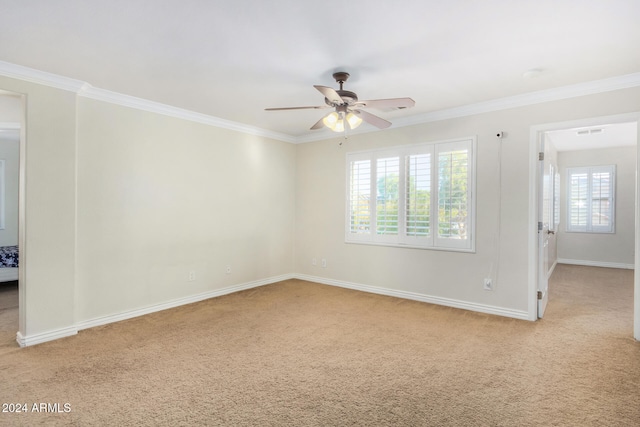 carpeted empty room featuring ceiling fan and crown molding