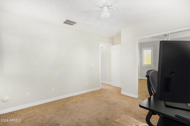 carpeted office space featuring ceiling fan