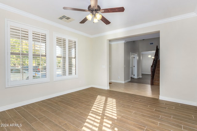 empty room with hardwood / wood-style flooring, ceiling fan, and crown molding