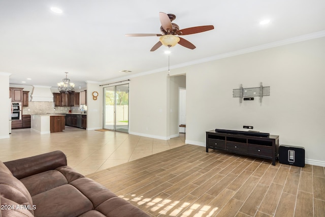 living room with ceiling fan with notable chandelier, light wood-type flooring, and ornamental molding