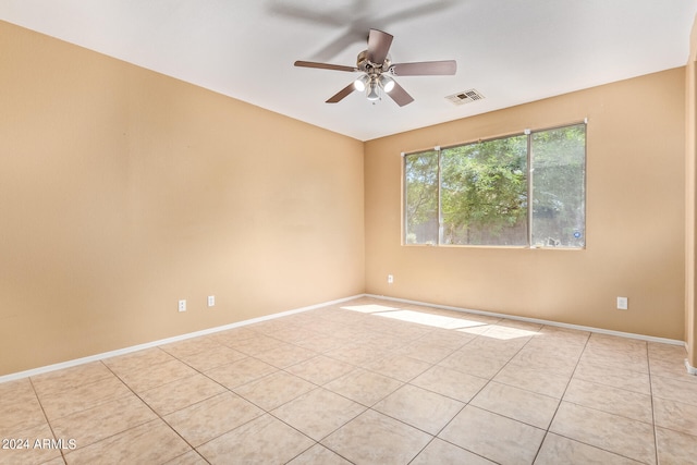 empty room with ceiling fan and light tile patterned floors