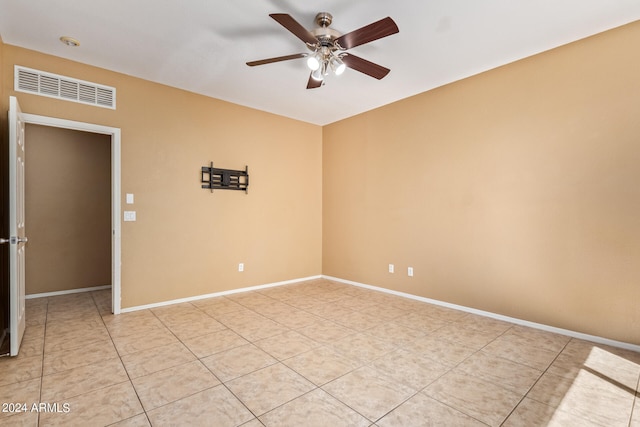 tiled spare room with ceiling fan