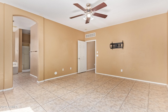 empty room with ceiling fan and light tile patterned flooring