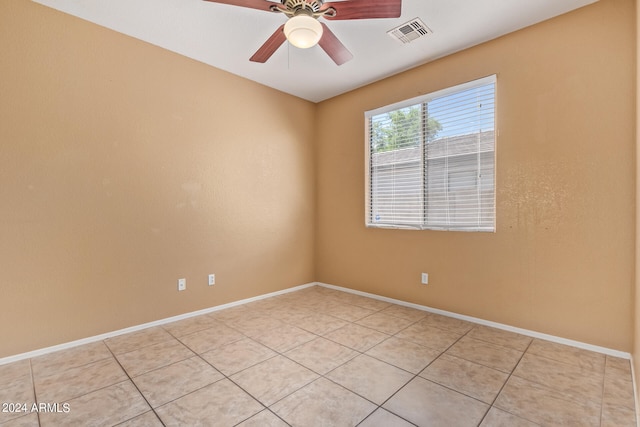 empty room with ceiling fan and light tile patterned flooring