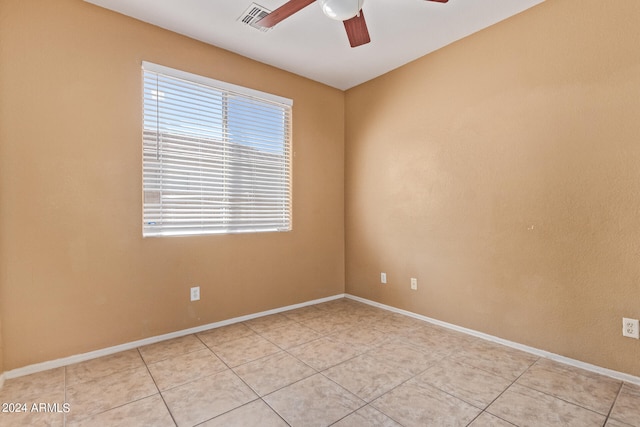 tiled spare room featuring ceiling fan