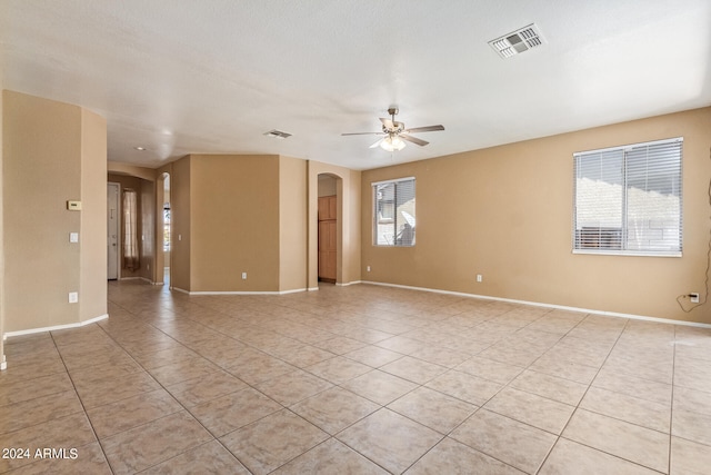 unfurnished room with ceiling fan, light tile patterned floors, and a textured ceiling