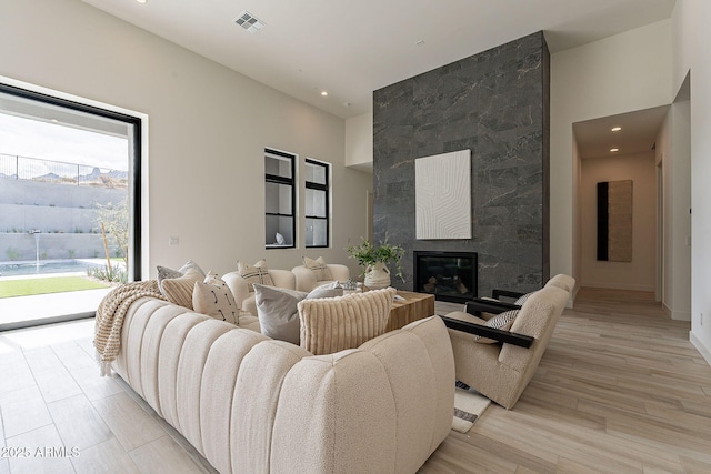 living room featuring light wood-type flooring and a tile fireplace