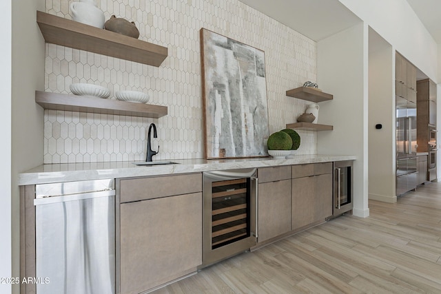 bar featuring sink, tasteful backsplash, beverage cooler, and light hardwood / wood-style floors