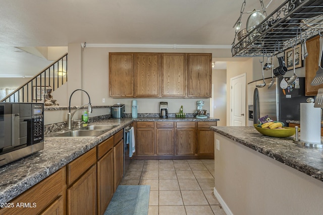 kitchen featuring light tile patterned flooring, appliances with stainless steel finishes, sink, and crown molding