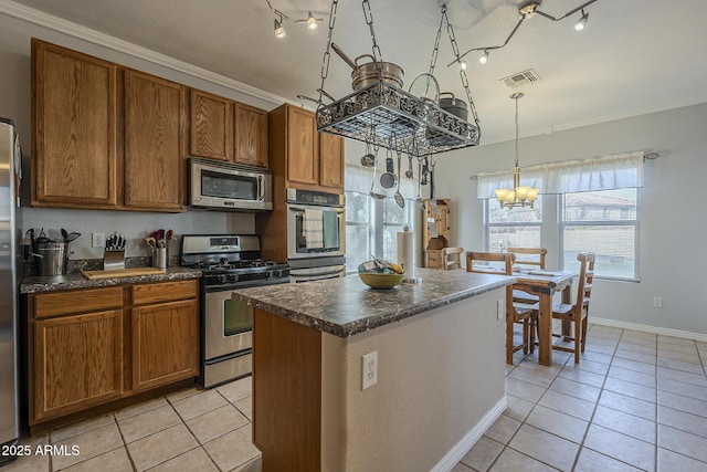 kitchen with stainless steel appliances, light tile patterned flooring, a center island, and an inviting chandelier