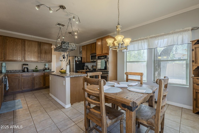 dining room with ornamental molding, light tile patterned flooring, and an inviting chandelier