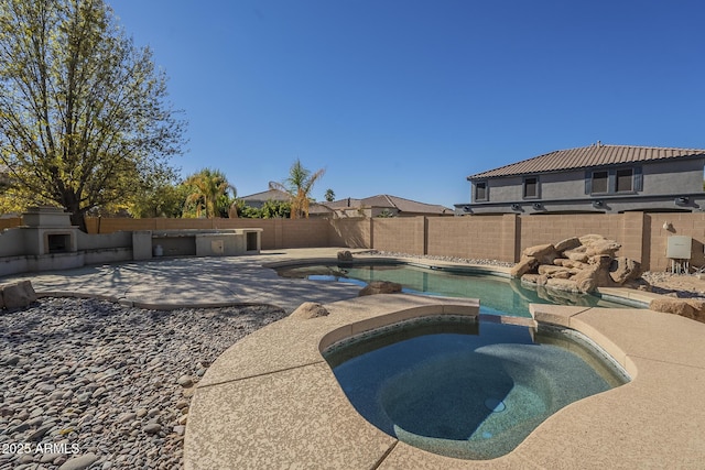 view of pool featuring a patio area, an outdoor fireplace, and an in ground hot tub