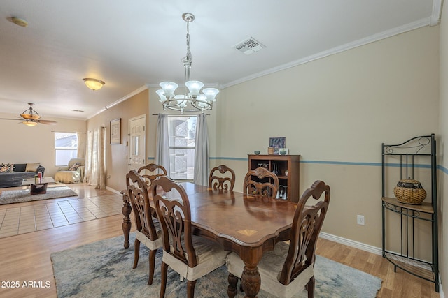 dining space featuring crown molding, light hardwood / wood-style flooring, and ceiling fan with notable chandelier