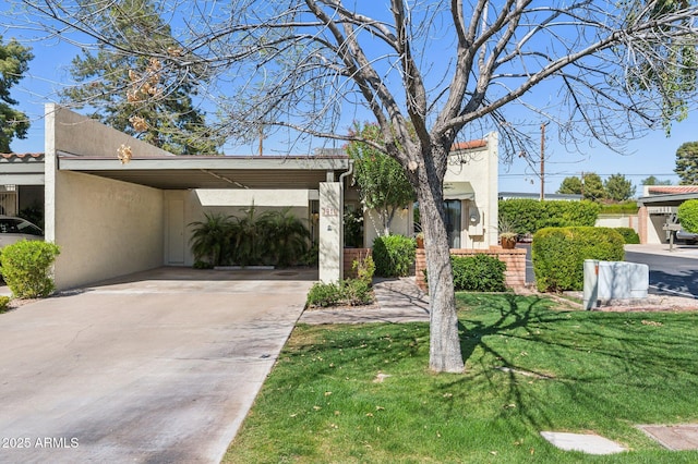 view of front of property with a carport, stucco siding, driveway, and a front lawn