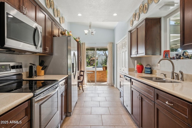 kitchen featuring an inviting chandelier, a sink, stainless steel appliances, light countertops, and a textured ceiling