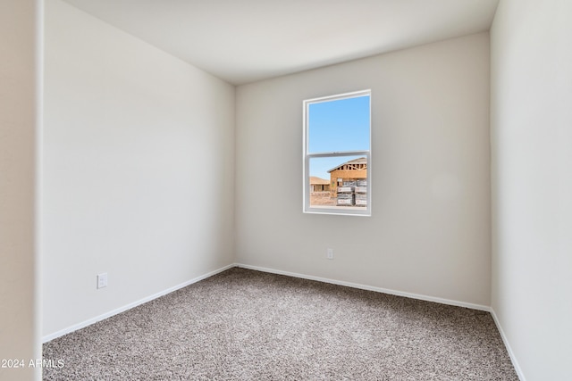 spare room featuring carpet floors and baseboards