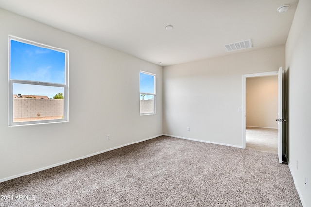 unfurnished room featuring carpet, visible vents, and baseboards