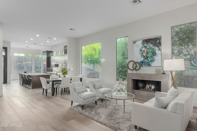 living room featuring light hardwood / wood-style floors and a tiled fireplace